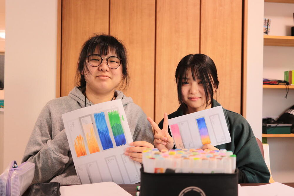 作品を見せてくれる生徒たち